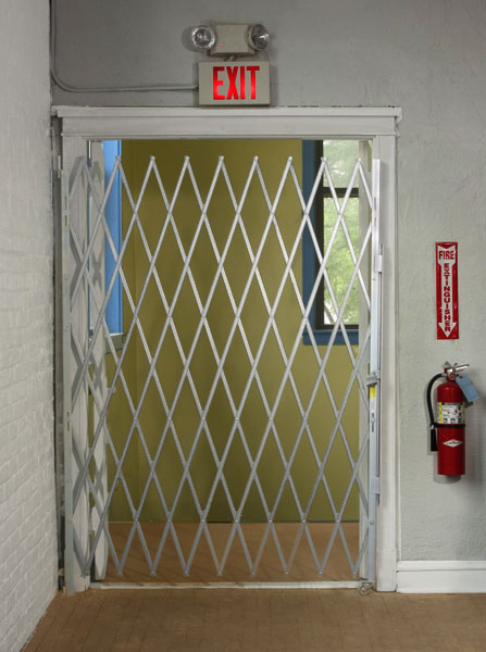 Folding gate on an interior doorway marked with an exit sign