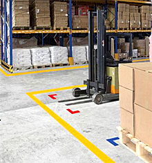 Warehouse floor marked with tape to signal placement of forklifts and pallets