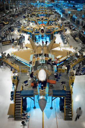 work platforms and workers surrounding an F22 jet under construction