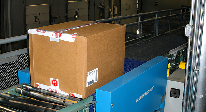 In-motion scale integrated with conveyor system for retail distribution center