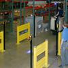 Pedestrians wait to cross as forklift comes to a halt, obeying the red light showing in the forklift lane