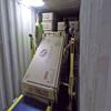 two men handling a large box inside a freight trailer