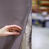 Acoustic curtain is made of viscoelastic vinyl material with layers of sound dampening metal particle fiber and an aluminum sound shield