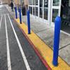 Blue bollards in front of a store with sliding glass doors