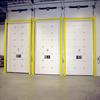 Three yellow goal post style guardrails in front of white dock doors