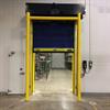 Yellow goal post style guardrail in front of a halfway open overhead door
