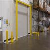 Yellow goal post style guardrail in front of a dock door in a warehouse