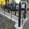 Black handrail and bollards at the end of an outdoor ramp