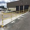 Yellow handrail outdoors near warehouse dock doors