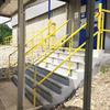 Yellow handrail on steps leading up to exterior door