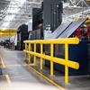 Yellow guardrail near equipment in a warehouse