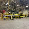 Yellow guardrail in front of equipment in a warehouse