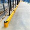 Row of yellow floor level guardrail in a warehouse
