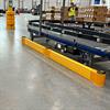 Yellow floor rail next to curved conveyor in a warehouse