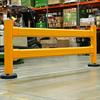 Yellow guardrail in front of a forklift and loaded pallet rack