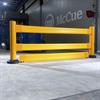 Yellow guardrail in dramatically lit room with McCue logo on wall
