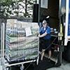 Delivery person rolling full folding cart off of truck