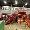 Mezzanine with elevated office and red stairs in warehouse