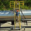 Rear view of Cantilever Mobile Work Platform with optional safety cage as worker climbs stairs