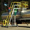 Side angle view of Cantilever Mobile Work Platform with optional safety cage as worker climbs stairs