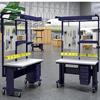 Rolling workbenches with small parts bins on rails, perforated wallboard for tools, drawers and lighting used in aviation plant