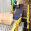 woman placing boxes on a conveyor inside a freight trailer
