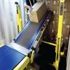 person loading boxes onto a conveyor inside a freight trailer