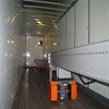 Inside of trailer, with conveyor equipped with fan and light extended all the way to the end