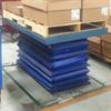 Lift table with blue skirt loaded with pallets