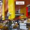 Yellow prongs either side of an orange pallet rack beam connected with a bolt underneath the beam