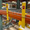Two yellow brackets attached to an orange pallet rack beam