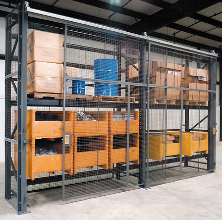 Pallet rack loaded with bins, boxes and drums, protected by cage with sliding door