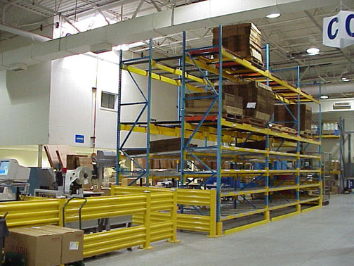 A rack picking module and conveyor system protected by steel guard rails.