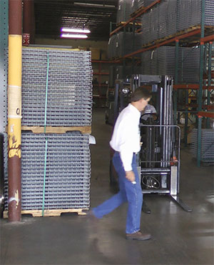 pedestrian passing in front of a forklift at a dock door