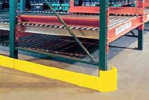 Floor-level guardrail along a pallet rack upright