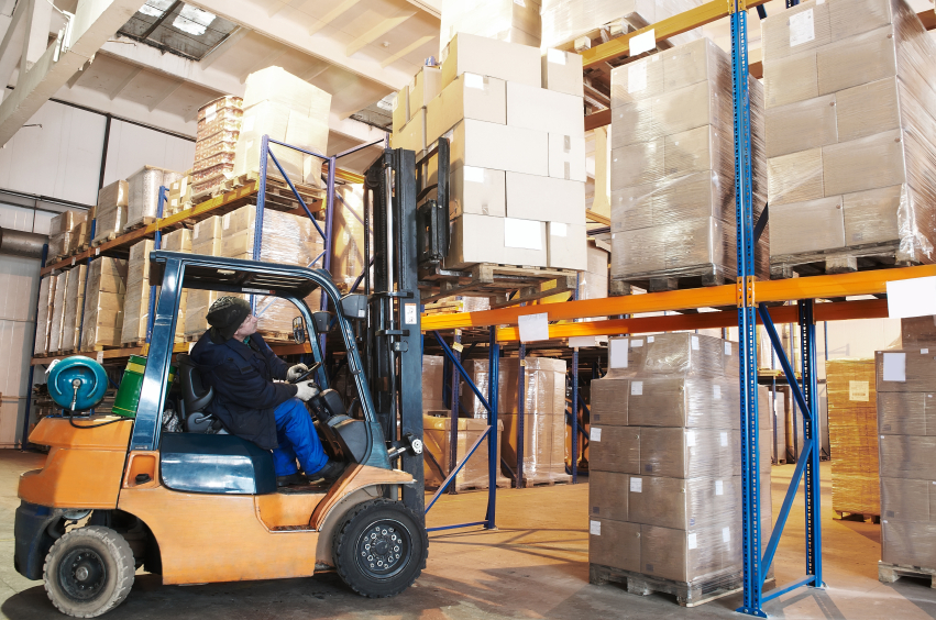 Forklift raising pallet load onto pallet rack