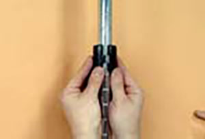 hands snapping plastic sleeve around post