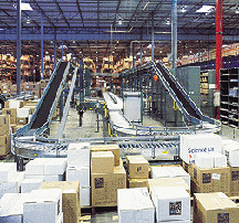 view of McGraw-Hill warehouse with conveyors, shelving, and stacks of boxes