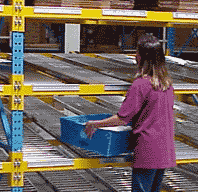 worker with tote in front of gravity flow rack