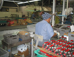 worker with totes of parts at Robroy industrial facility