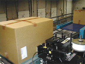 automatic labeler applying label to corrugated carton