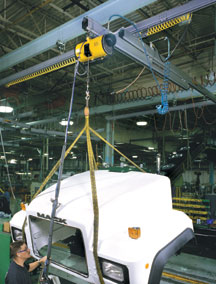 Man using an air balancer to move a truck body component